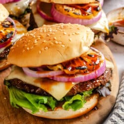 Aloha burgers sitting on a wooden cutting board.