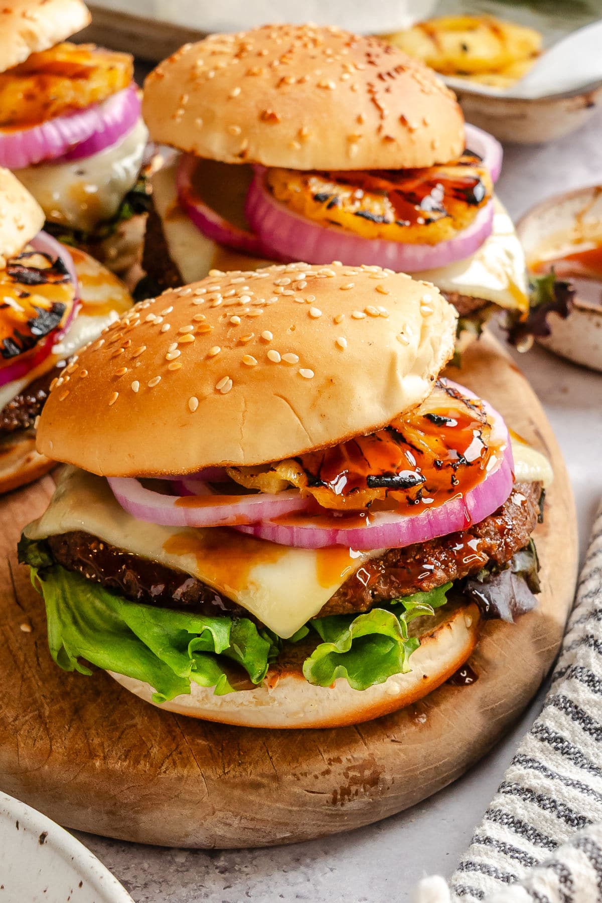 Aloha burgers sitting on a wooden cutting board.