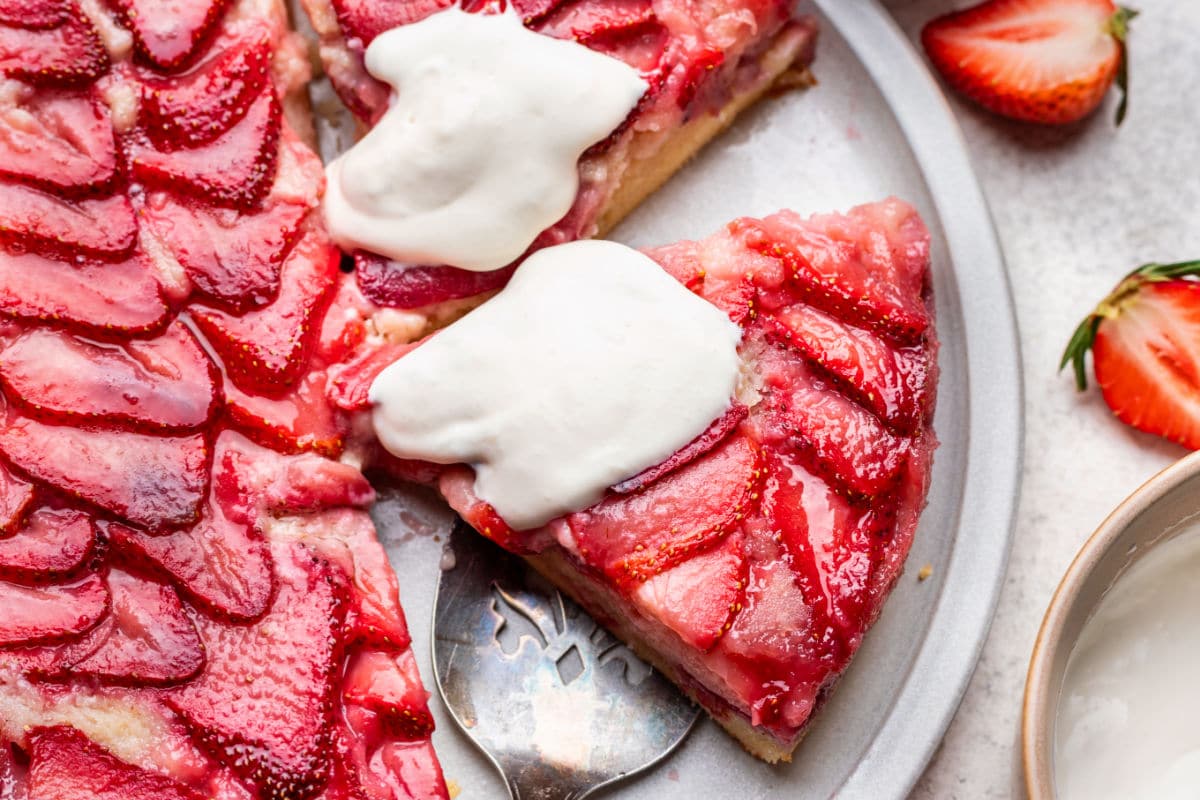 A cake server under a slice of strawberry upside down cake. 