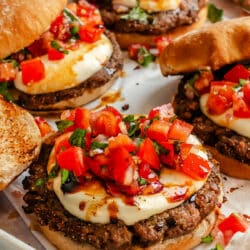 Bruschetta burgers on parchment paper.