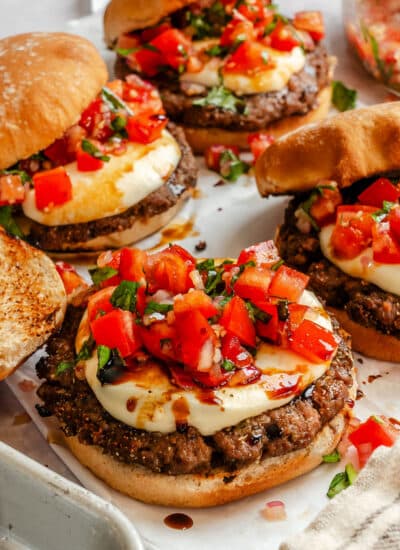 Bruschetta burgers on parchment paper.