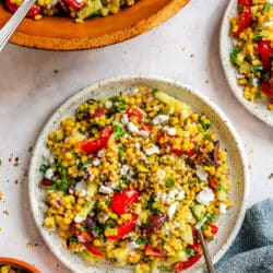A plate of pearl couscous salad next to the bowl of salad.