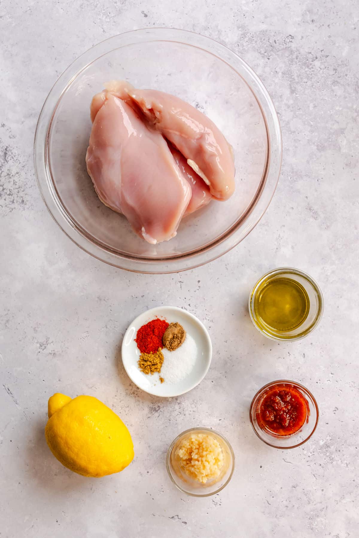 Ingredients for harissa chicken in dishes.