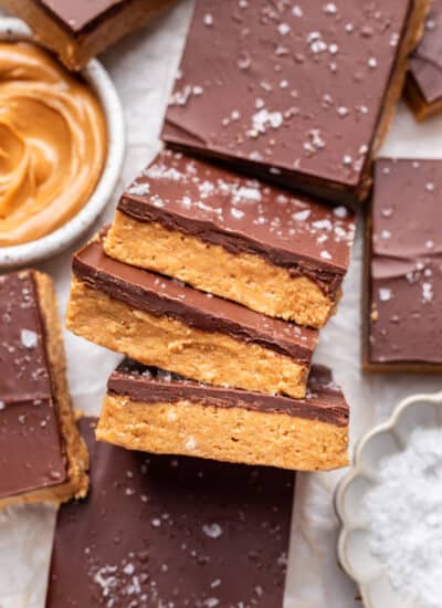 Three no bake peanut butter bars sideways overlapping more bars.