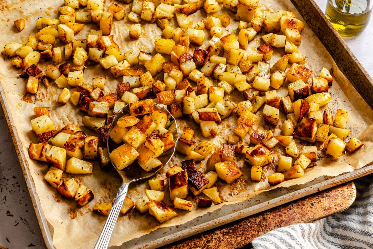 Roast potatoes on a sheet pan lined with brown parchment paper.