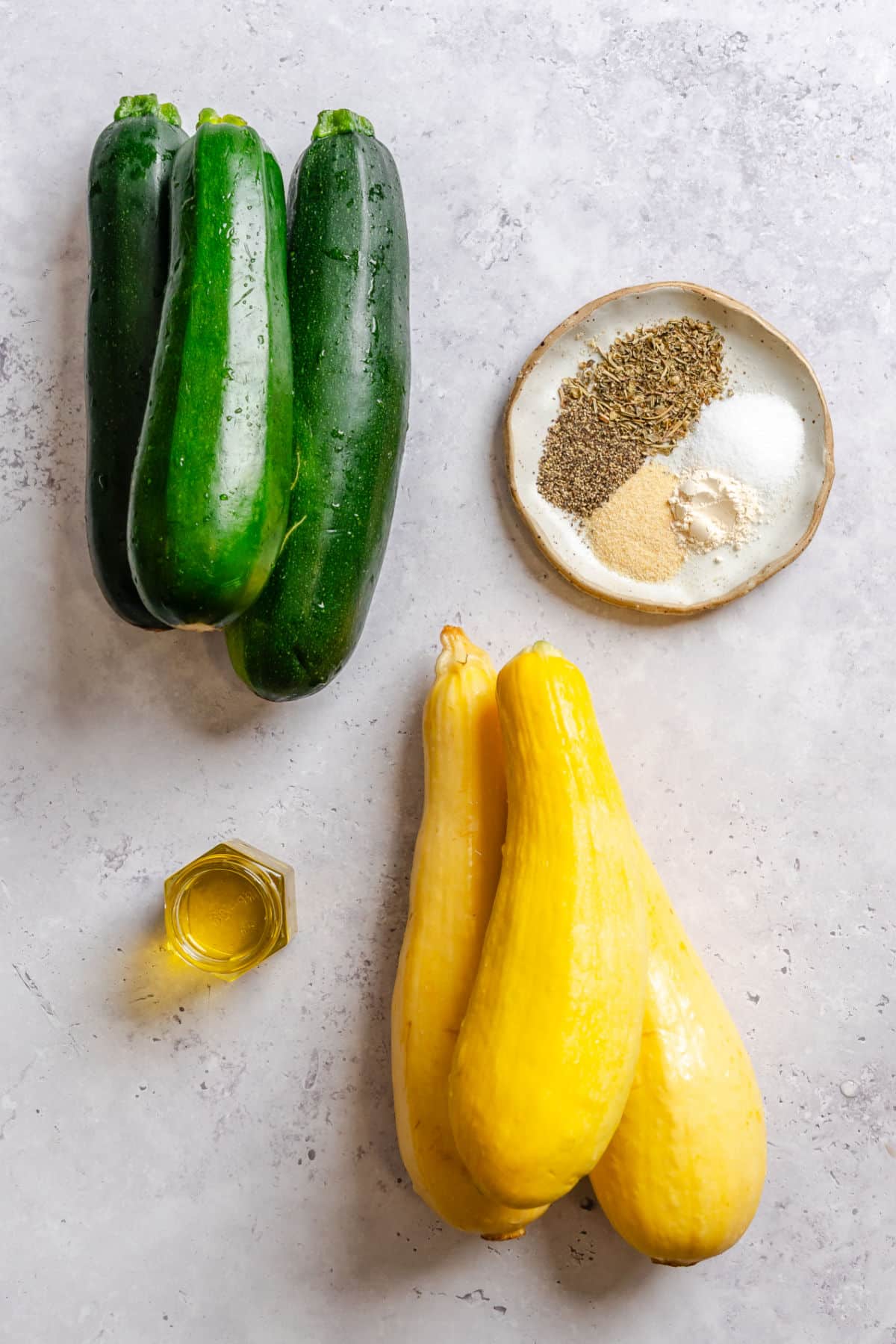 Ingredients for roasted summer squash and zucchini in dishes.