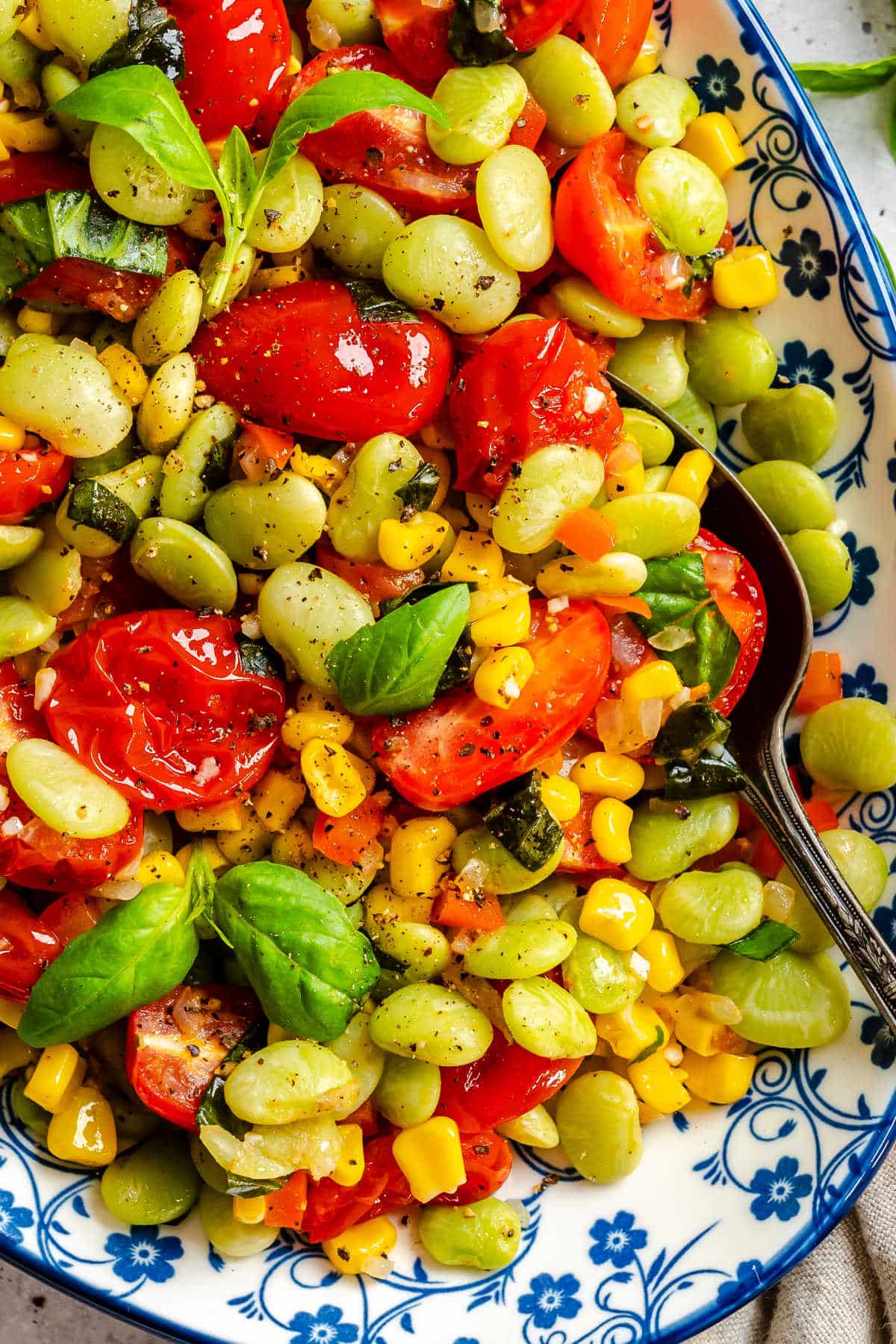 Close up of succotash on a blue patterned serving dish.
