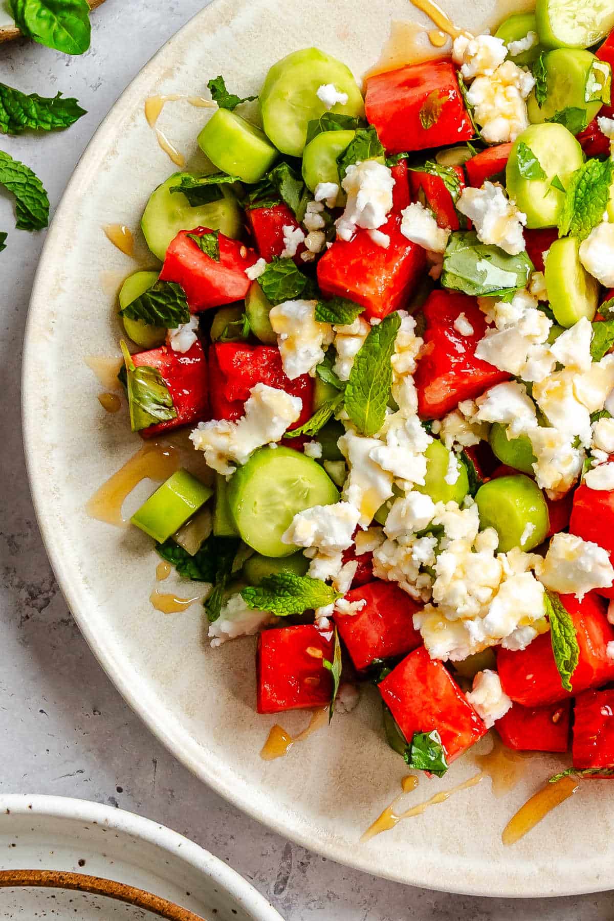 A plate of watermelon feta salad drizzled with honey. 