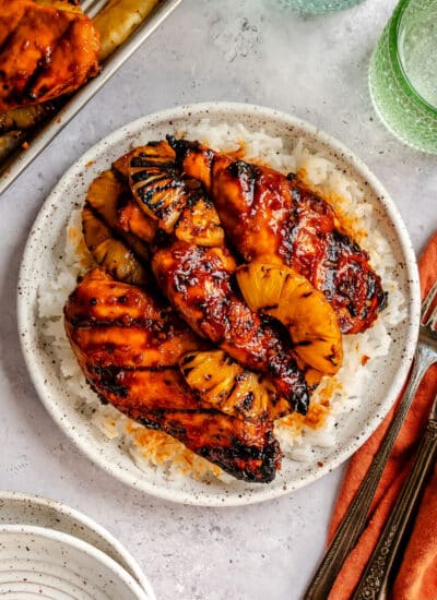 A plate of grilled huli huli chicken and pineapple on rice.