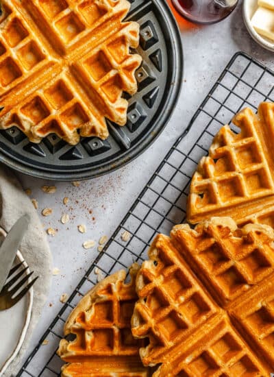 Cottage cheese waffles overlapping next to the waffle on the waffle iron.