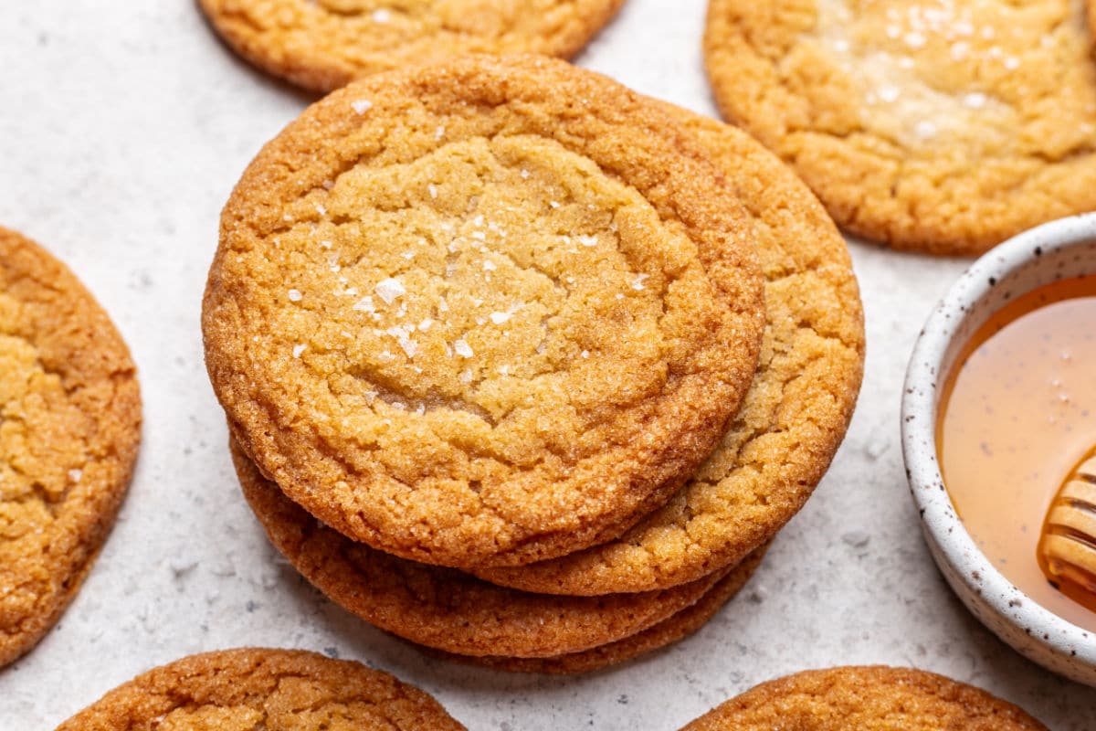A stack of honey cookies topped with a sprinkle of flaky salt.
