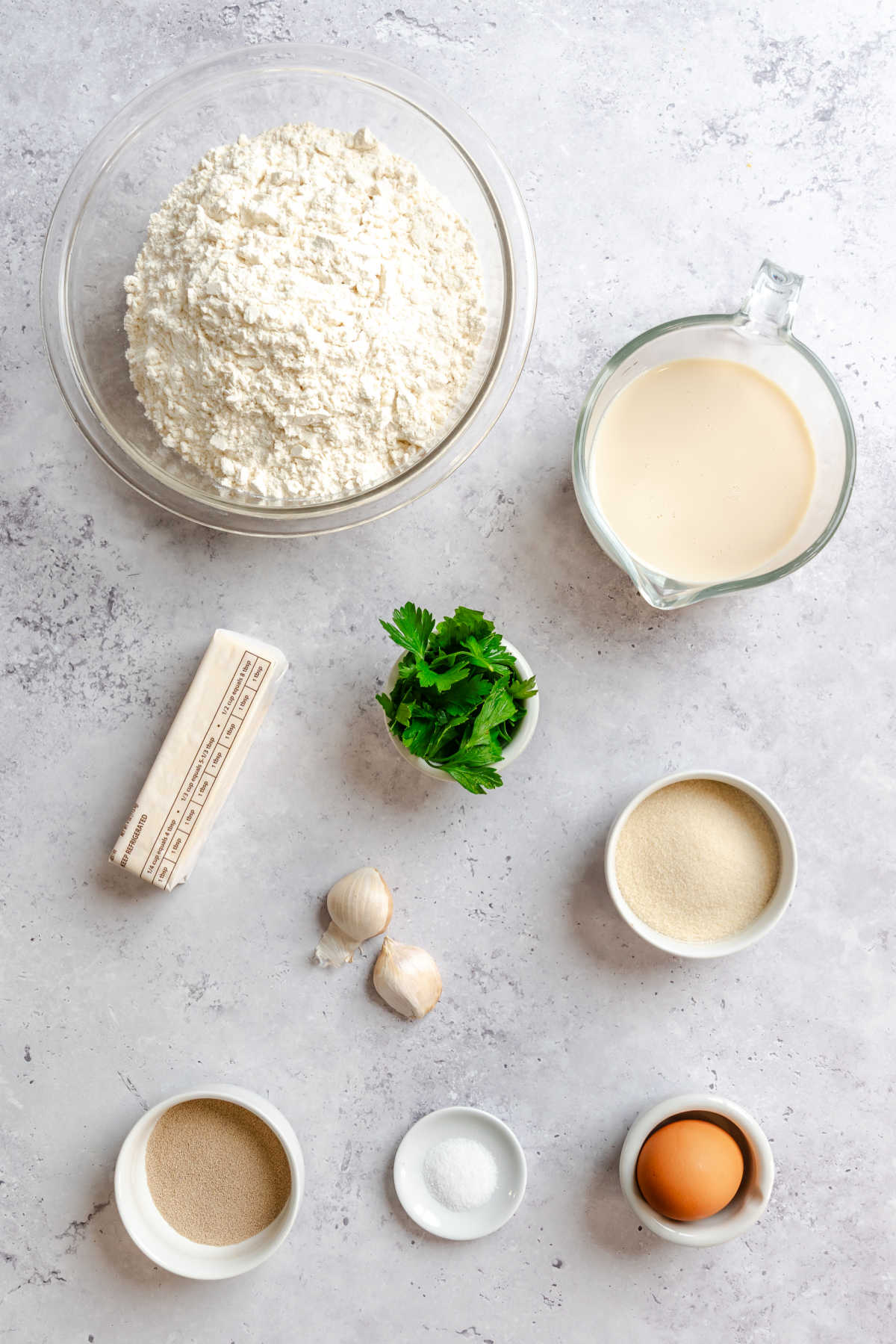 Ingredients for garlic butter rolls in dishes.