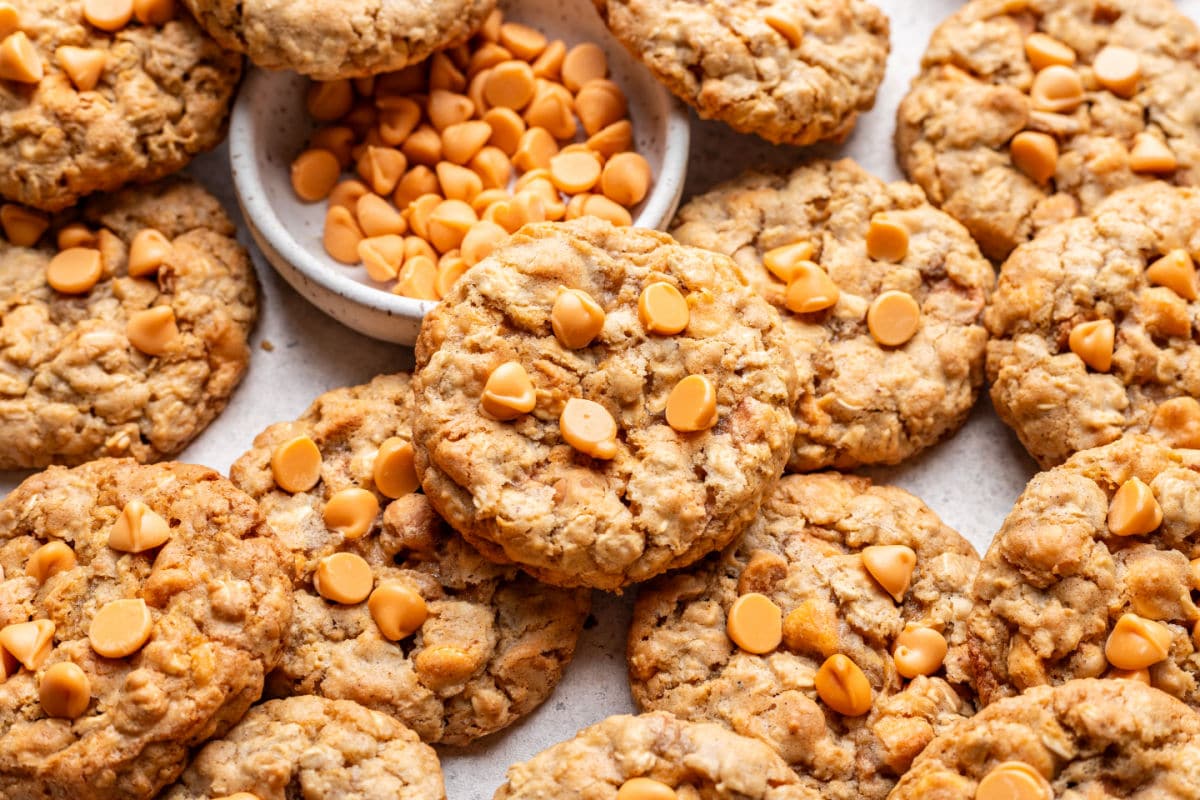 Oatmeal scotchies overlapping around a dish of butterscotch chips.