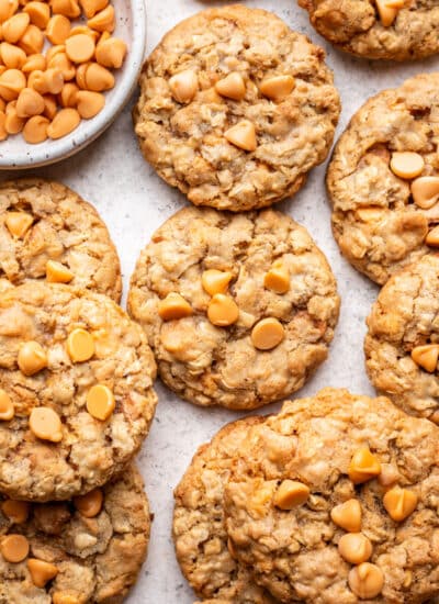 Overlapping oatmeal scotchies next to a dish of butterscotch chips.