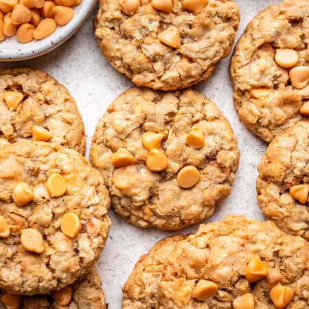 Overlapping oatmeal scotchies next to a dish of butterscotch chips.