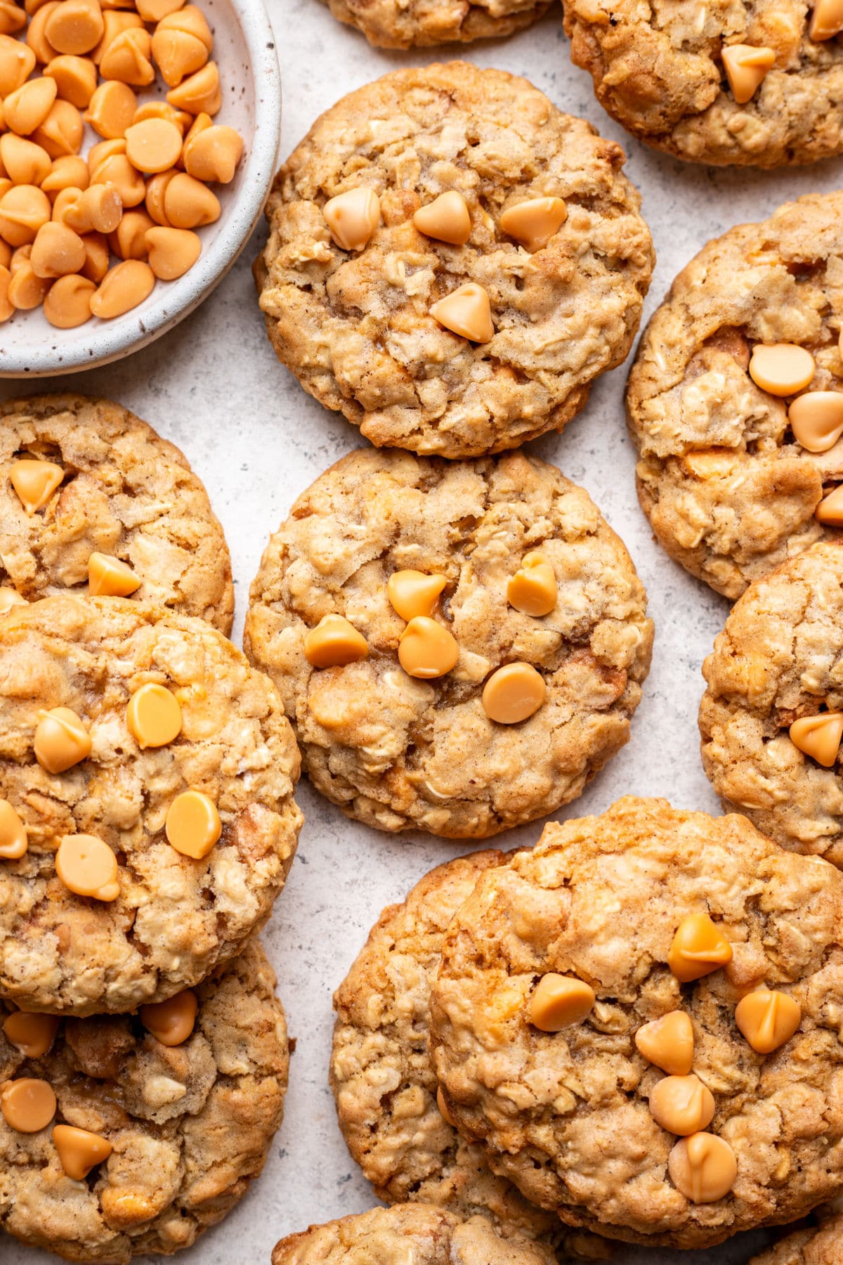 Overlapping oatmeal scotchies next to a dish of butterscotch chips.
