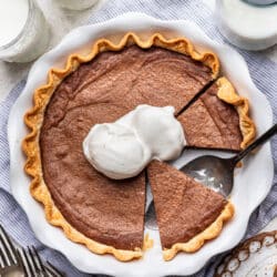 A brownie pie with two scoops of vanilla ice cream on it.
