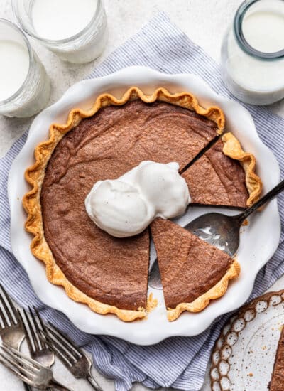 A brownie pie with two scoops of vanilla ice cream on it.